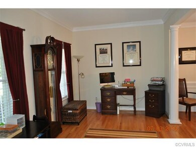 Living room with wood flooring, crown moulding and