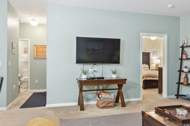 Living area featuring light carpet and baseboards