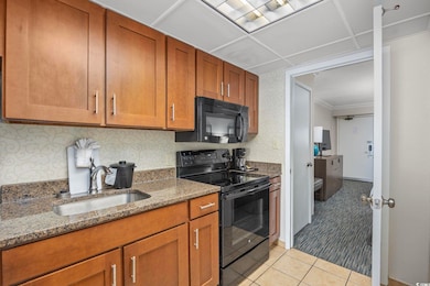 Kitchen featuring stone countertops, light tile pa