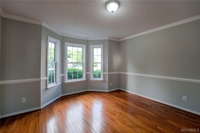 Wood floored spare room with crown molding and a t