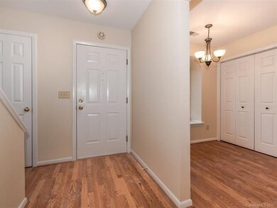 Entry hall with hardwood floors and coat closet. T