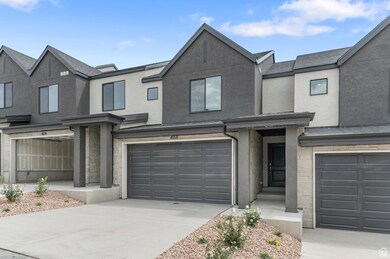 View of front of home featuring stone siding, stucco siding, an attached garage, and driveway