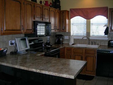Gorgeous kitchen, tile back splash,tile floors, black appliances