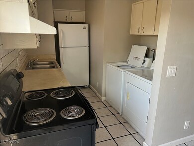 Clothes washing area with light tile patterned flo