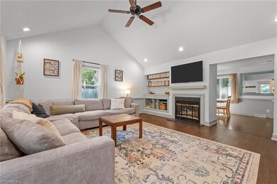 Living room with built in shelves, vaulted ceiling and gas log fireplace.