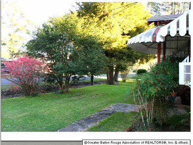 Mature shrub and tree-shaded front yard.