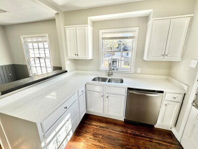 Kitchen with quartz counters, dishwasher, white ca