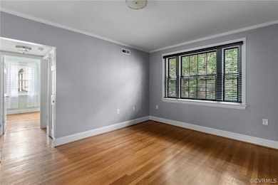 Spare room with crown molding and hardwood / wood-