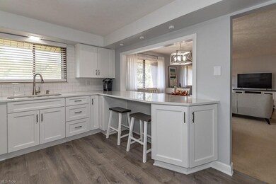 Kitchen with a center island, white cabinets, dark