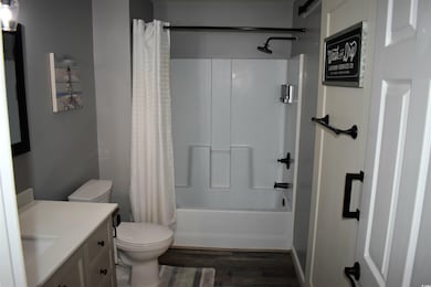 Full bathroom featuring wood finished floors, show