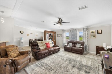Living room with a ceiling fan, light wood-style f