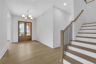 Entryway featuring a chandelier, wood finished flo