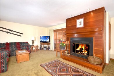 Great room with wood-burning fireplace opens to su