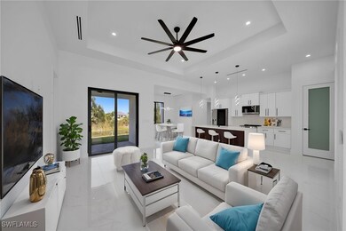Living area featuring a tray ceiling, a ceiling fa