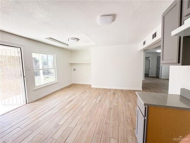 Unfurnished living room featuring a textured ceiling and light wood-type flooring