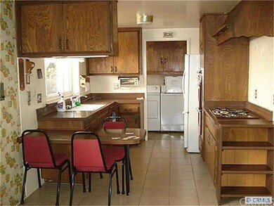 Kitchen with laundry room in background
