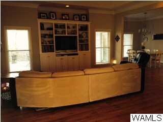 Family room has built-ins, hardwood floors, crown