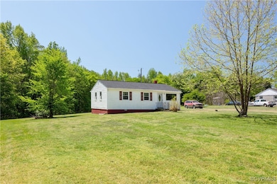 View of front of home with a front lawn and a chim