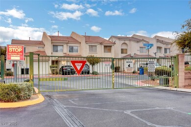 View of asphalt street featuring a gated entry, cu