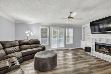 Living area featuring crown molding, a textured ce
