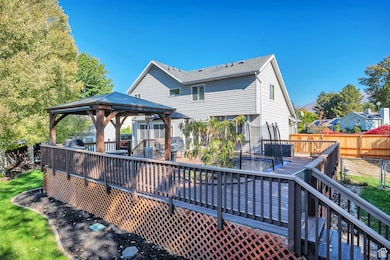 Back of house featuring a wooden deck, a gazebo, a fenced backyard, and stairs