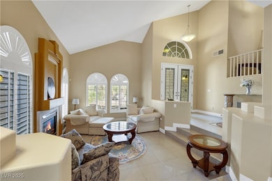 Living room with baseboards, visible vents, a glas