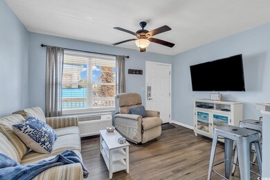 Living room with ceiling fan and wood-type floorin