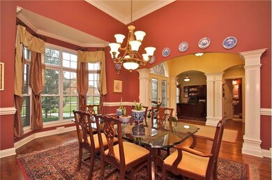 Another view of dining room, notice the beautiful bay window with custom window treatments, hardwoods,arched doorway leading to entry foyer.  Custom Lighting and 14' Ceilings Welcome Your Guest.