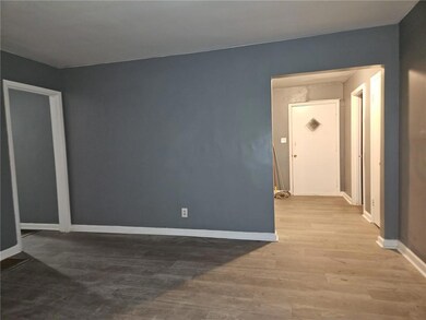 Spare room featuring wood finished floors and base