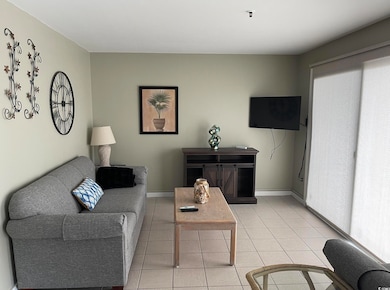 Living room with light tile patterned floors and baseboards