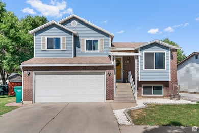 Split level home featuring an attached garage, driveway, brick siding, and a shingled roof