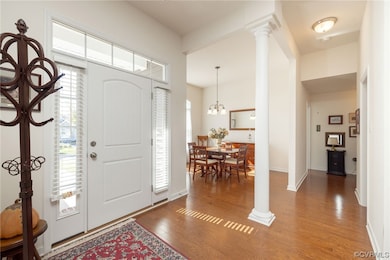Foyer featuring ornate columns, an inviting chande