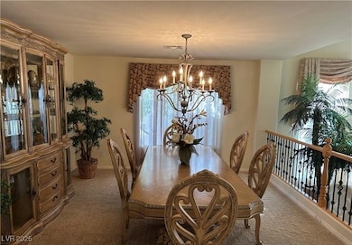Carpeted dining space featuring a chandelier and b