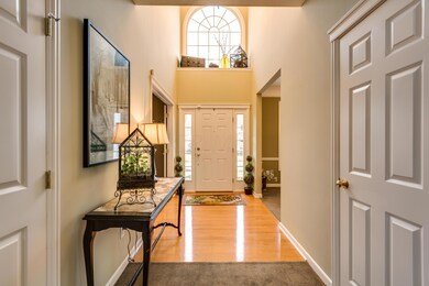 Entry with hard wood flooring, sidelights and large open window.