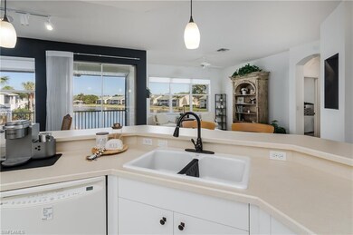 Kitchen with white cabinetry, sink, pendant lighti