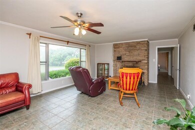 Large living with front facing windows and a wood 