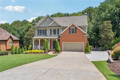 View of front of property with driveway, brick siding, covered porch, an attached garage, and a shingled roof