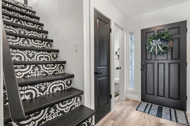 Entrance foyer with a textured wall and wood fini
