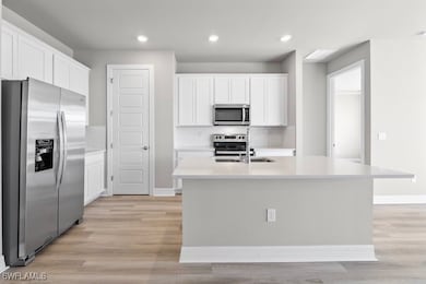 Kitchen featuring white cabinets, stainless steel