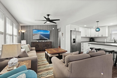 Living room featuring ceiling fan and sink