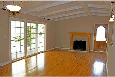 High ceilings with open wood beams, fireplace with