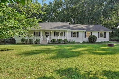 Ranch-style house featuring covered porch and roof with shingles
