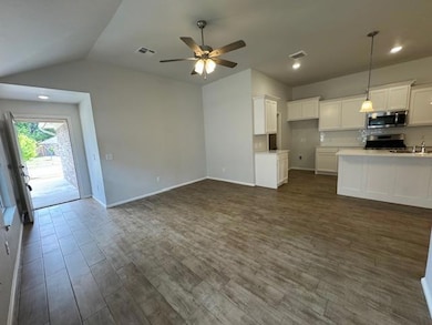 Kitchen with dark wood finished floors, white cabinetry, recessed lighting, pendant lighting, and appliances with stainless steel finishes