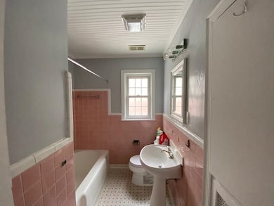 Full bath featuring tile walls, a wainscoted wall, shower / washtub combination, and tile patterned floors
