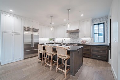 Kitchen featuring built in fridge, white cabinetry