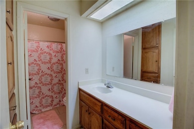Full bath with vanity, light tile patterned floors, and a shower with shower curtain