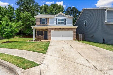 View of front of property featuring brick siding, an attached garage, and driveway