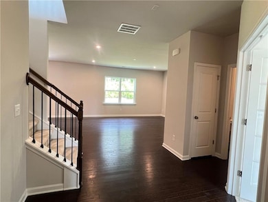 Hallway featuring dark wood finished floors, stairs, and recessed lighting