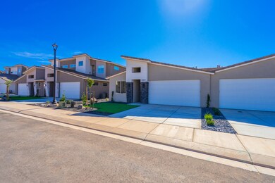 View of front facade with concrete driveway, stucco siding, stone siding, and a garage