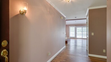Entry foyer with closet and hardwood floors.